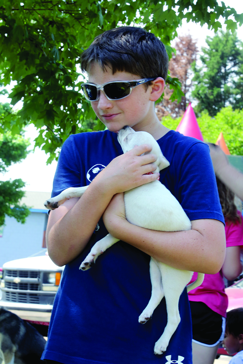 Charles Day holds Willow at the Clifford's Army Rescue Extravanganza during National Kids to Park and Dog Rescue Day at Shelby City Park