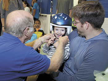 Children receive helmets during Brain Bonanza