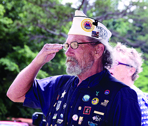 Randy Robbins a Vietnam Veteran salutes during the National Anthem