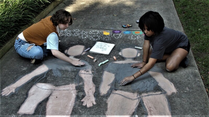 Ruthie Ware and Kinsley Black draw self portraits at the Chalk Fes