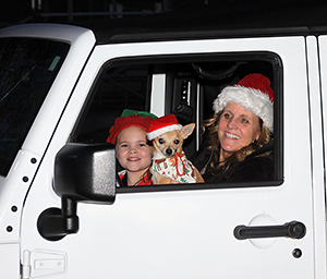 Julia Baker (age 6), Dog Oliver and Jami Bumgarner talk to Santa at the Shelby City Park Carrousel Christmas Drive -Thru.