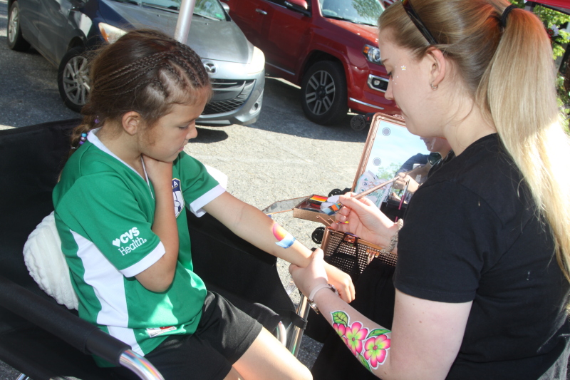 Mallie Boggs gets her arm painted by Shea Kirkpatrick at the Historic Stamey Store Event Center Craft Fair in Fallston on May 6th, 2023.  