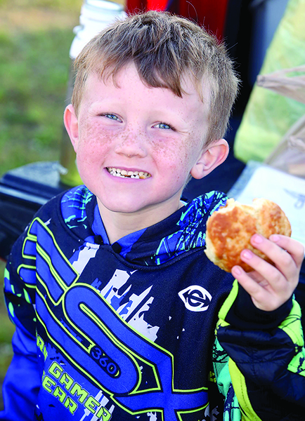 Grayson Holland enjoys a biscuit from Campfield Memorial Baptist Church at Ellenboro's yard sale.
