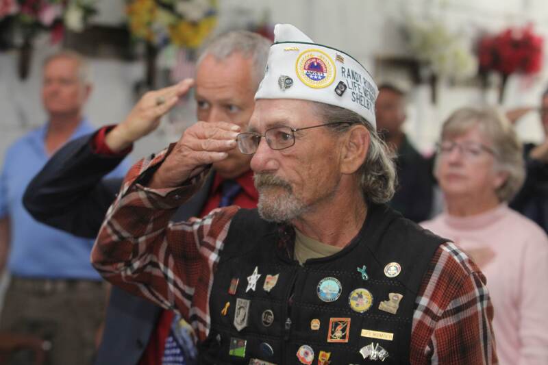 Veterans salute during the National Anthem