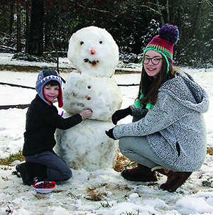 Brother and Sister Walter and Elizabeth Wilson make a snowman. 